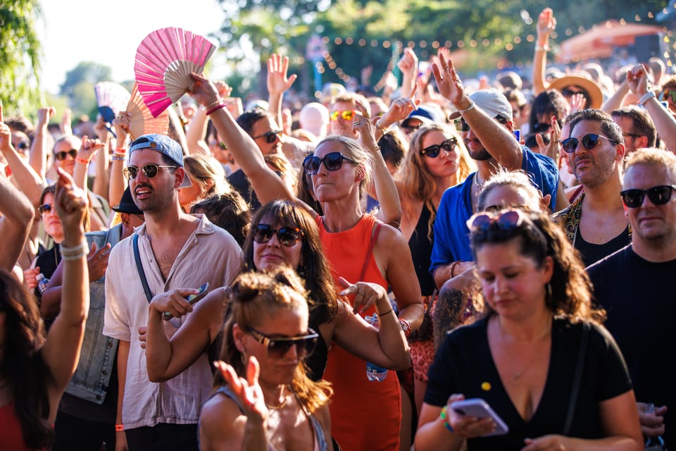Publikum tanzt im Sonnenlicht bei einem sommerlichen Open-Air-Event